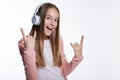 Cheerful girl listening to music and showing sign of horns