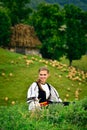 Young Romanian girl smiling, old shepherd house in the background