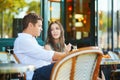 Young romantic couple drinking coffee in a cozy outdoor cafe in Paris, France Royalty Free Stock Photo