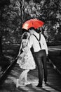 Young romantic couple in love flirting in rain. Red umbrella Royalty Free Stock Photo