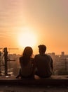 young romantic couple in love sitting together with a modern city urban view at sunset Royalty Free Stock Photo