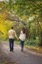 Young romantic couple in love walking in the autumn park holding hands Royalty Free Stock Photo