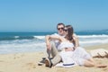 Young romantic couple sitting on the beach