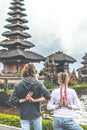 Young romantic couple of trourists on the Ulan Danu temple background. Bali island.