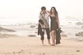 Young romantic couple walking along beach after night out Royalty Free Stock Photo