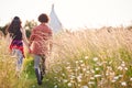 Young Romantic Couple Walking Through Field Towards Teepee On Summer Camping Vacation Royalty Free Stock Photo