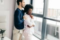 Romantic mixed race couple standing by the window thinking about their future. Royalty Free Stock Photo