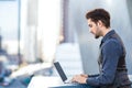 Young romantic man working on his laptop in the city Royalty Free Stock Photo