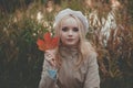 Young romantic woman with fall leaf. Pretty tenderness autumn model looking at camera Royalty Free Stock Photo