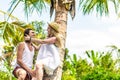 Young romatic couple tourist under the coconut palm. Bright green and yellow picture. Bali island. Indonesia. Royalty Free Stock Photo