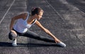 Young runner fit woman streching before exercises outdoors. Athletic female strech after workout outside. Sport and