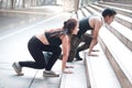 Young runner man and woman lover doing exercise together outside, partner buddy runner stretching body at staircase before run