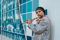 Young, Russian male playing a wooden flute and busking on the streets of Lagos, Portugal