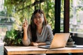 Young 20s Asian woman looking at camera while wearing a protective mask with laptop, mobile phone, notebook for working Royalty Free Stock Photo