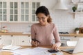 Woman makes calculations, pay bills through e-bank app on smartphone Royalty Free Stock Photo