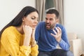 Young sad afraid woman and her violent screaming man. Young couple fighting at home, boyfriend shouting at girlfriend. Stressed Royalty Free Stock Photo