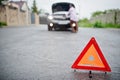 Young sad african woman stand with emergency triangle against car with popped hood. Transportation, vehicles problems and Royalty Free Stock Photo