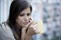 Young sad beautiful woman suffering depression looking worried and wasted on home balcony