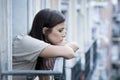 Young sad beautiful woman suffering depression looking worried and wasted on home balcony