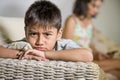 Young sad and bored Asian child at home couch feeling frustrated and unattended while mother networking on mobile phone as Royalty Free Stock Photo