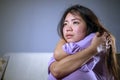 Young sad and depressed Asian Japanese woman at home sofa couch crying desperate and helpless suffering anxiety and depression fee Royalty Free Stock Photo