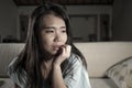 Young sad and depressed Asian Korean woman crying desperate sitting at home sofa couch suffering depression problem and anxiety