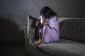 Young sad and depressed Asian Korean woman at home sofa couch crying desperate and helpless suffering anxiety and depression feeli Royalty Free Stock Photo