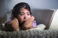 Young sad and depressed Asian Korean woman at home sofa couch crying desperate and helpless suffering anxiety and depression feeli Royalty Free Stock Photo