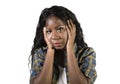 Young sad and depressed black African American woman holding her head feeling sick and stressed isolated on studio background suff