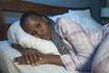 Young sad and depressed black African American woman lying on bed at home unhappy and sleepless at night feeling overwhelmed Royalty Free Stock Photo