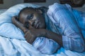 Young sad and depressed black African American woman lying on bed at home unhappy and sleepless at night feeling overwhelmed Royalty Free Stock Photo