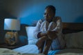 Young sad and depressed black African American woman lying on bed at home unhappy and sleepless at night feeling overwhelmed Royalty Free Stock Photo