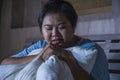 Young sad and depressed fat and chubby Asian girl feeling upset and desperate crying on bed at home victim of bullying and Royalty Free Stock Photo