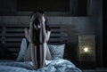 Young sad and depressed Latin woman sitting on bed thoughtful an