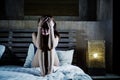 Young sad and depressed Latin woman sitting on bed thoughtful an