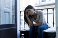 Desperate Latin woman sitting at home balcony looking destroyed and depressed suffering depression Royalty Free Stock Photo