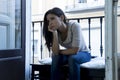 Desperate Latin woman sitting at home balcony looking destroyed and depressed suffering depression Royalty Free Stock Photo