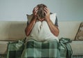 Young sad and desperate man at home sitting at sofa couch covering face with hands and pillow crying suffering depression and stre Royalty Free Stock Photo