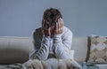 Young sad and desperate man at home sitting at sofa couch holding head with hands suffering depression and stress worried about pr Royalty Free Stock Photo