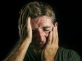 Young sad and devastated man crying desperate covering face with his hands feeling stressed and lost suffering pain and depression Royalty Free Stock Photo