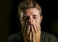 Young sad and devastated man crying desperate covering face with his hands feeling stressed and lost suffering pain and depression Royalty Free Stock Photo