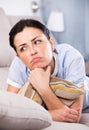 Young sad female lying on cozy sofa Royalty Free Stock Photo