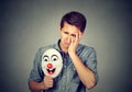 Young sad man with happy clown mask Royalty Free Stock Photo