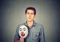 Young sad man with happy clown mask Royalty Free Stock Photo