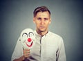 Young sad man with happy clown mask Royalty Free Stock Photo