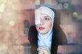 Young sad nun near window Royalty Free Stock Photo