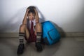 Young sad scared kid 8 years old in school uniform and backpack sitting alone crying depressed and frightened suffering abuse prob Royalty Free Stock Photo