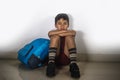 Young sad scared kid 8 years old in school uniform and backpack sitting alone crying depressed and frightened suffering abuse prob Royalty Free Stock Photo