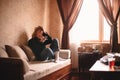 Young sad stressed woman using smart phone while sitting on sofa Royalty Free Stock Photo