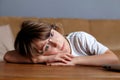 Young sad tired schoolboy, almost sleeps on desk